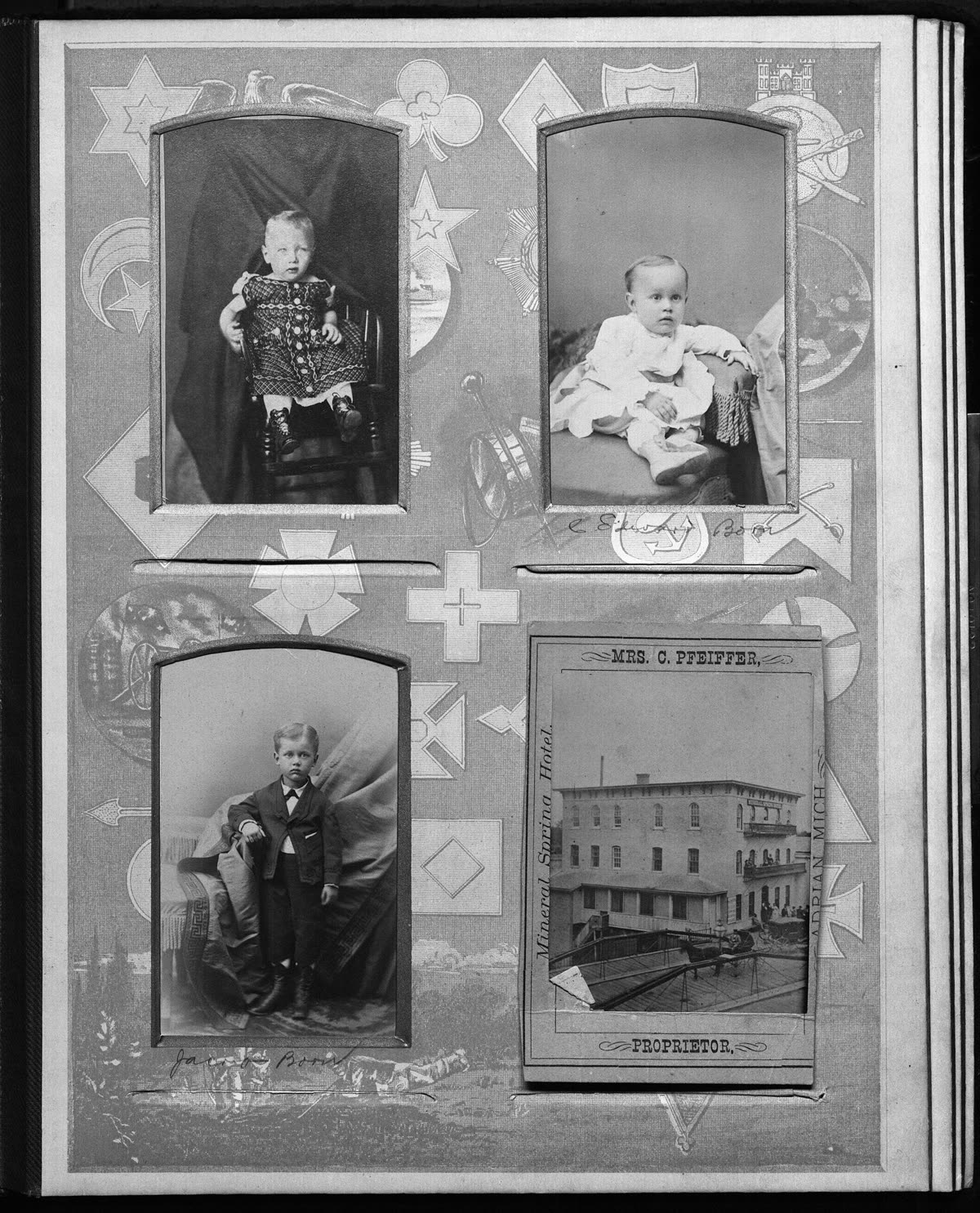 A page from an old family photograph album with four studio portraits of small children